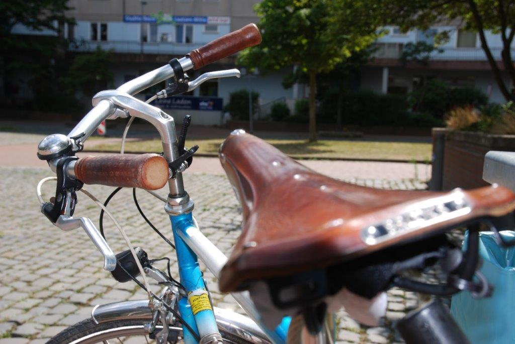 Ein älteres Fahrrad steht auf dem Marktplatz, verschwommen im Hintergrund kann man das Stadteilbüro erahnen. ©Stadt Laatzen