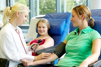 Ärztin misst vorbereitend Blutdruck bei einer Patientin