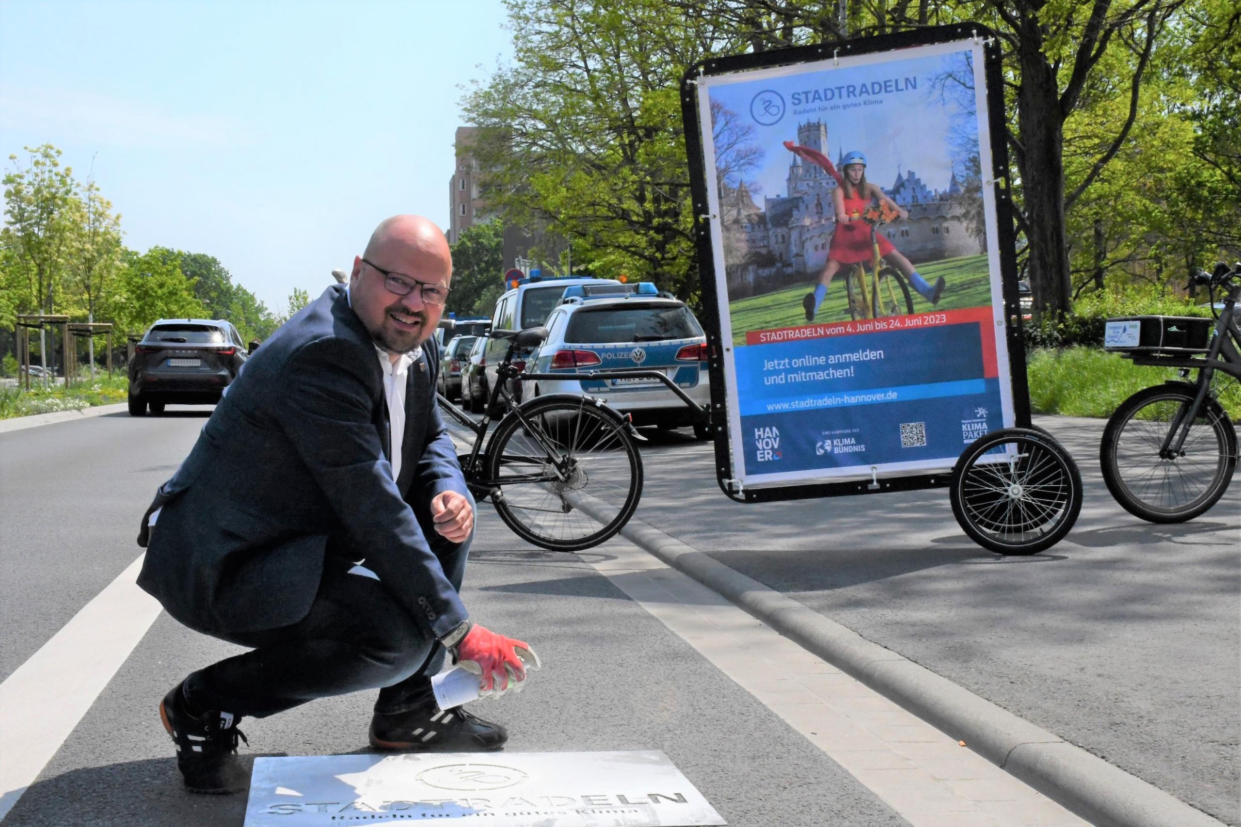 Bürgermeister sprüht das erste Logo auf die Straße.