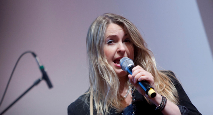 Frau, die in ein Mikrofon singt