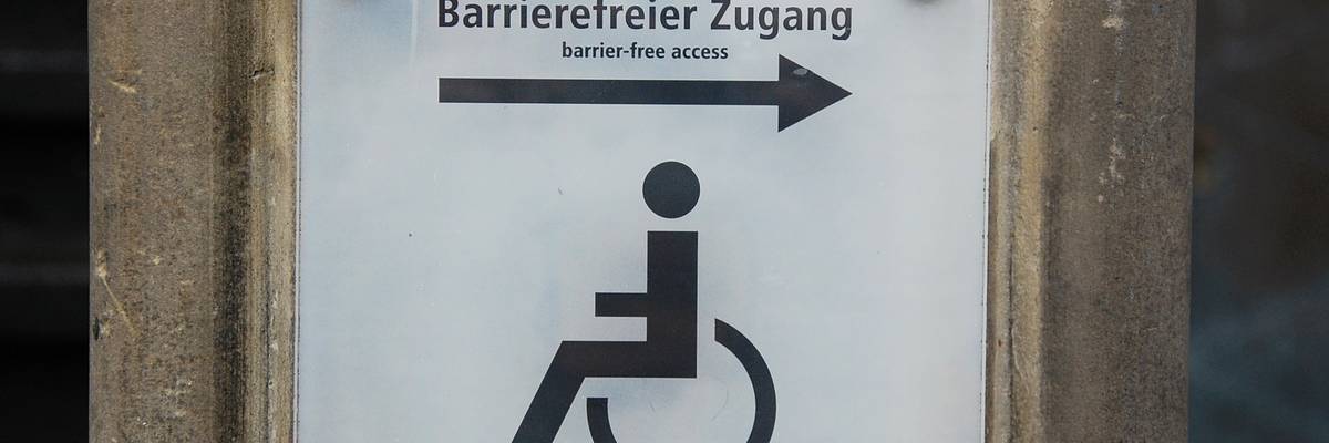 Ein Schild auf welchem Barrierefreier Zugang in Deutsch und Englisch geschrieben steht und ein Rollstuhlfahrer als Piktogramm abgebildet ist. ©Pixabay