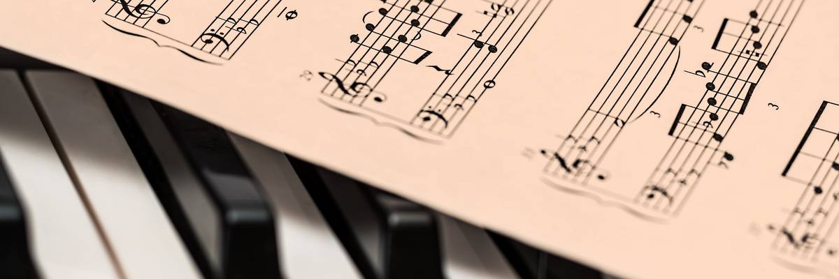 Notenblätter, die auf einer Tastatur liegen