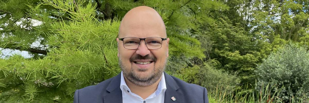 Portrait von Bürgermeister Kai Eggert im grünen Park der Sinne