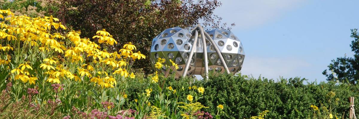 Insektenauge im Park der Sinne © Stadt Laatzen Kunstobjekt vor blühenden Sommerblumen. Das blühende Staudenbeet mitten auf einer Wiese.