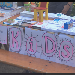 Es ist ein Ausstellungsstand zu sehen. Auf dem Stand liegen Zettel zu den Kinderrechten der Kinder.