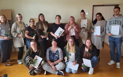 Gruppenbild zum Abschluss © Stadt Laatzen/ Karen Schlote Die Teilnehmenden stehe im Halbkreis zur Kamera. Sie halten alle ihre Teilnahmebescheinigungen und eine Blume in der Hand.