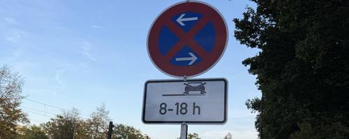 Schild steht an einer Straße.