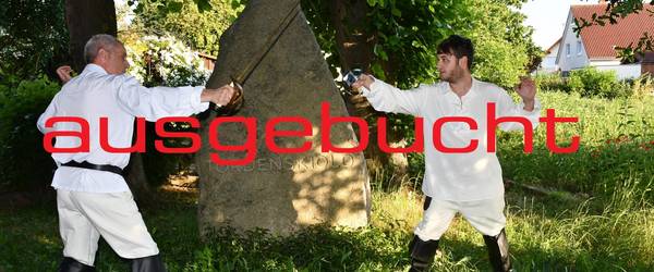 Nachgestelltes Duell mit Degen. Zwei Männer stehen sich bewaffnet gegenüber mit Schriftzug "abgesagt"