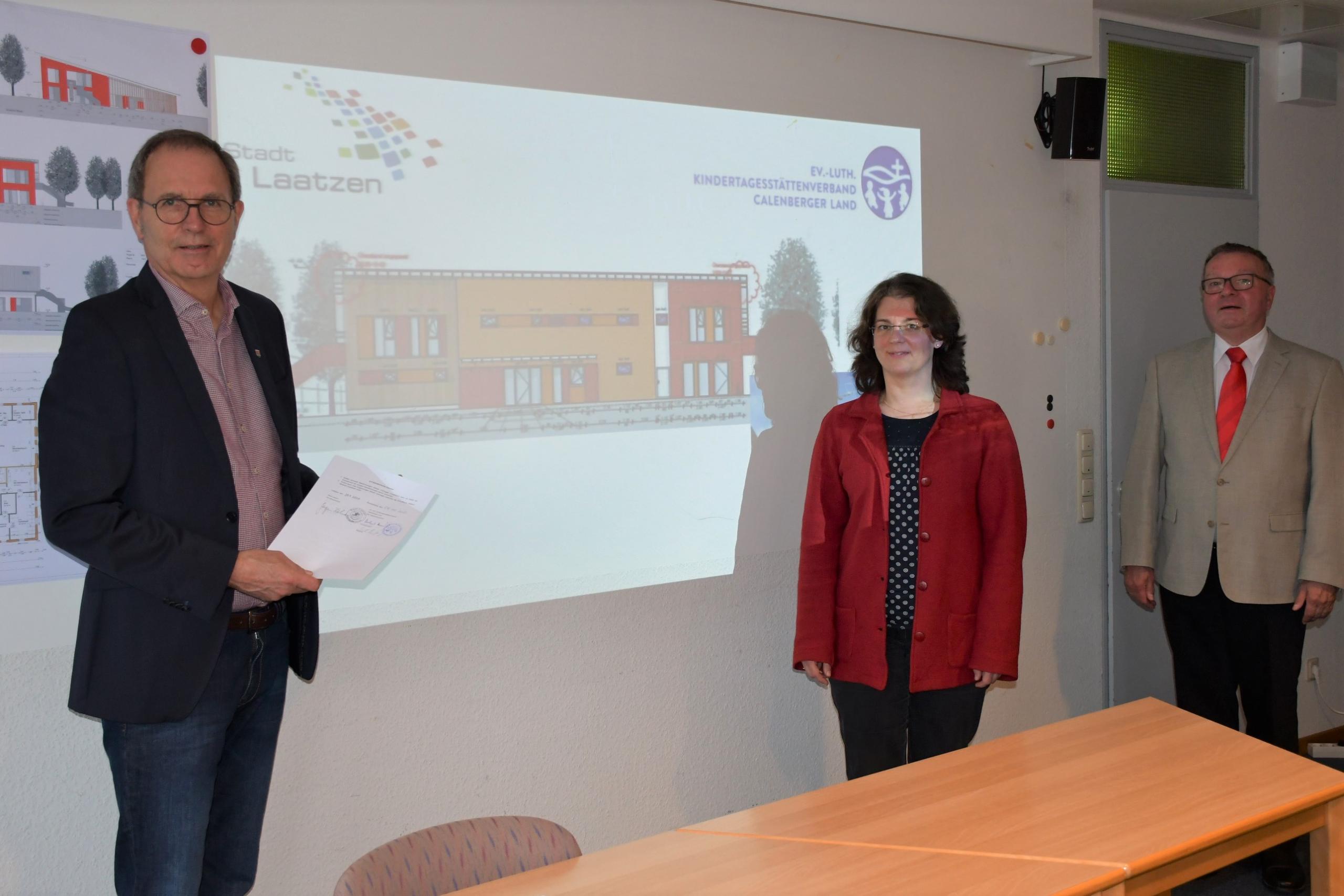 Drei Personen vor einer Bauzeichnung