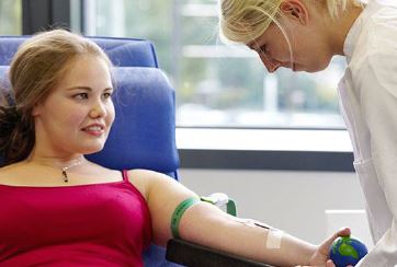 DRK Blutspendedienst nimmt Blut bei einer jungen Frau ab