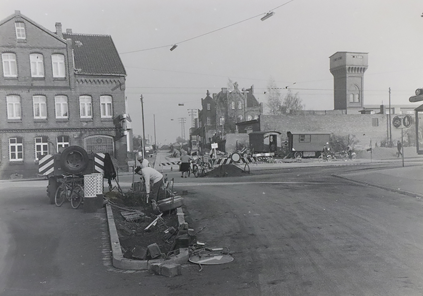 Auf dem Bild ist Alt Laatzen in den früheren Zeiten zu sehen. im Vordergrund sind zwei Männer mit Bauarbeiten beschäftigt und im Hintergrund ist die Straße abgesperrt.