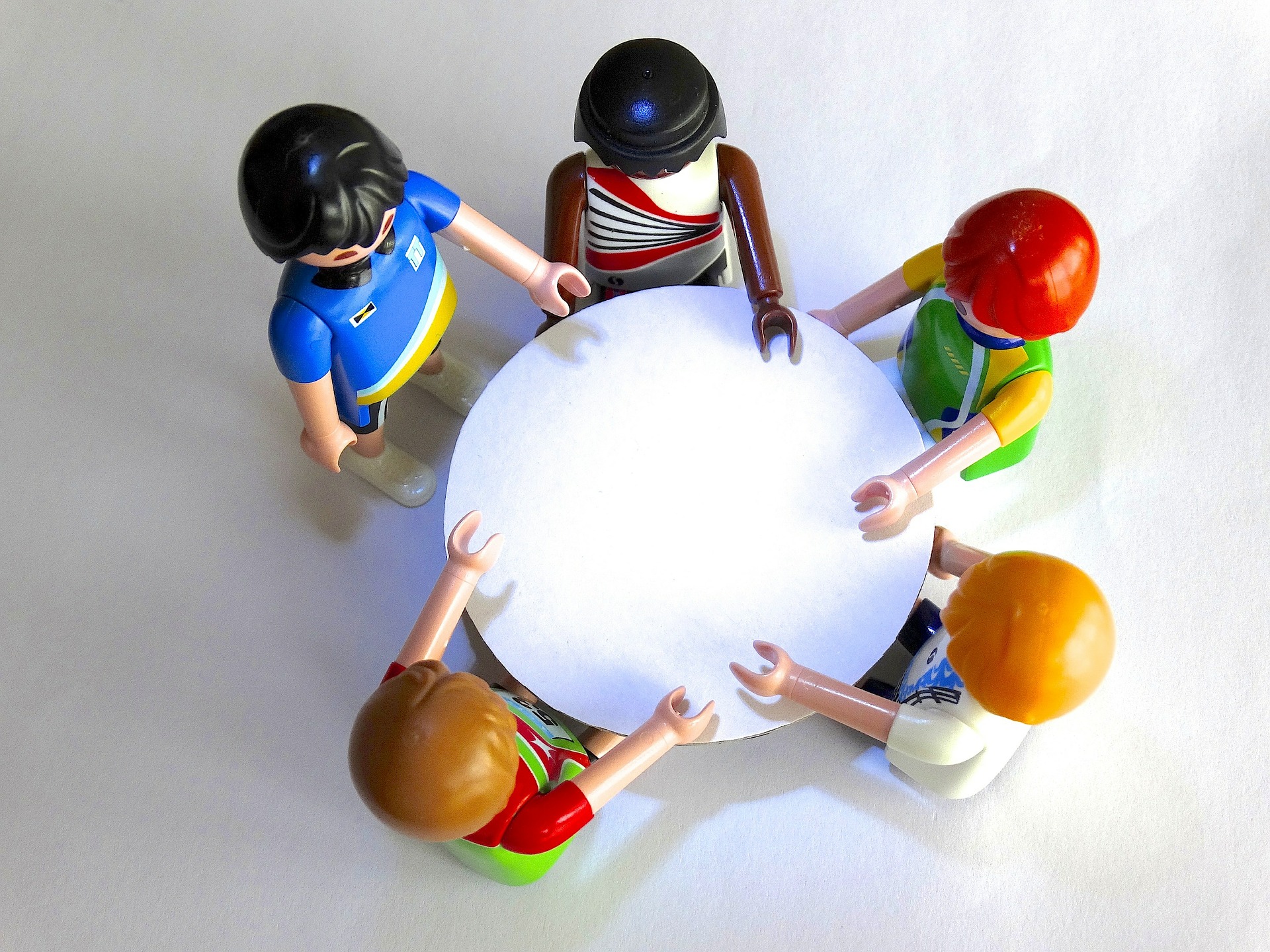 Mehrere Playmobilfiguren an einem runden Tisch stehend