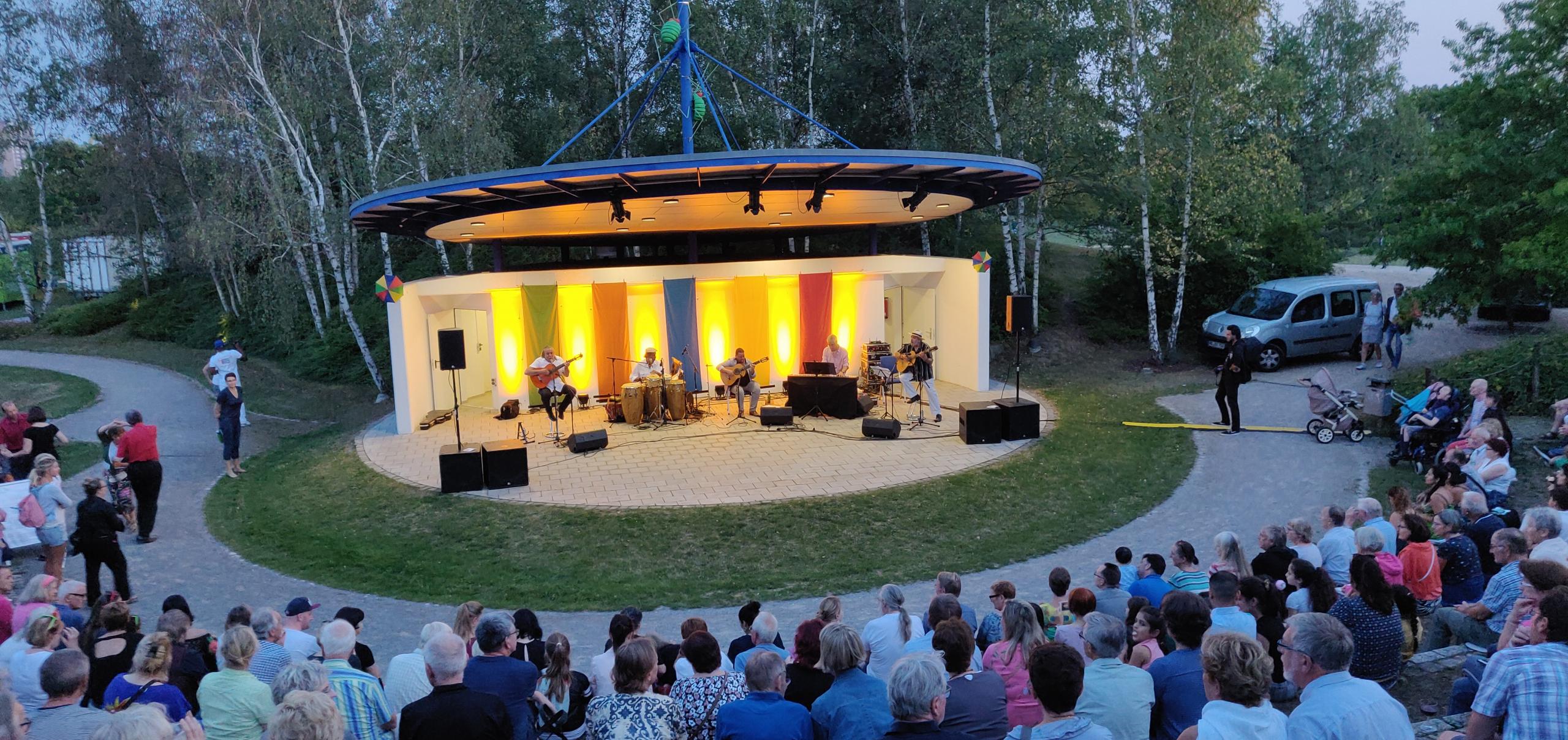 Blick von der vollbesetzten Tribüne der Kulturbühne im Park der Sinne  auf ein Konzert
