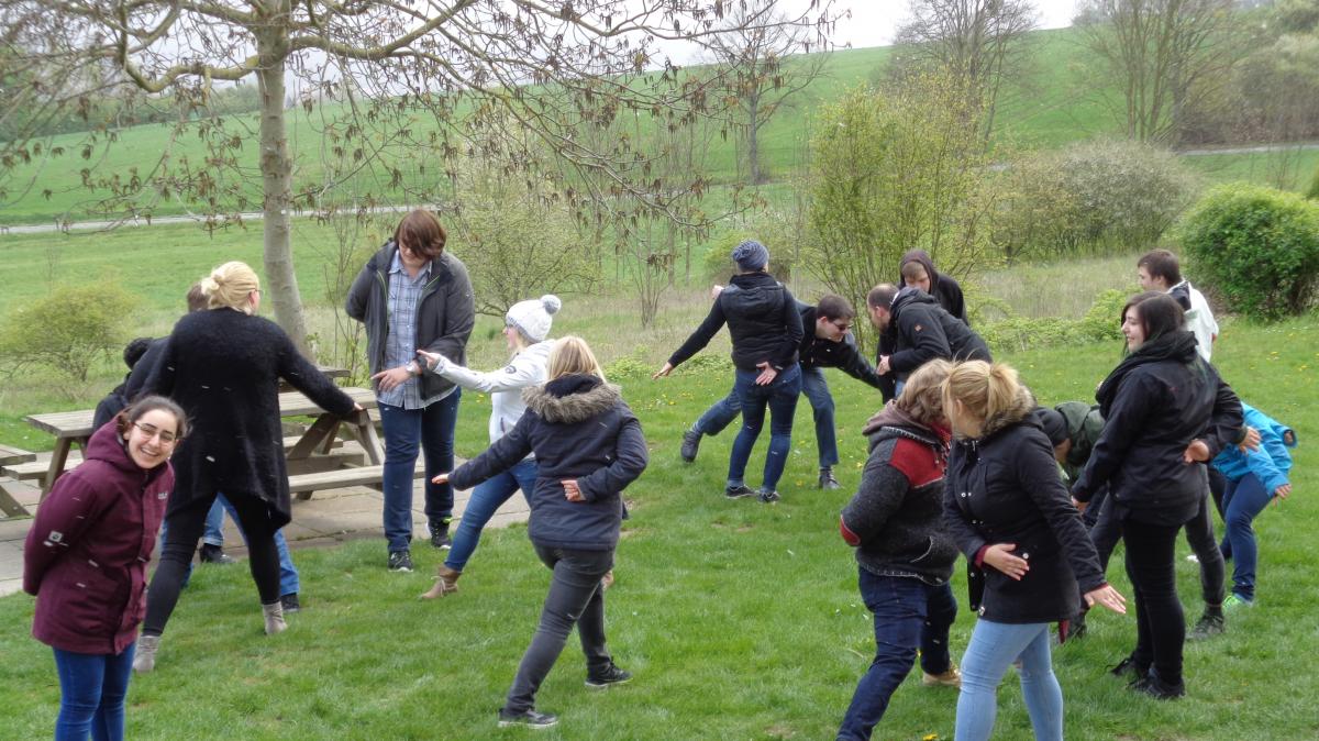 Jugendliche auf der Wiese beim Gruppenspiel