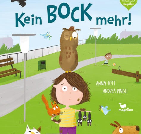 Ein Kind steht mit einer Eule auf dem Kopf und weiteren Tieren an ihrem Körper im Park