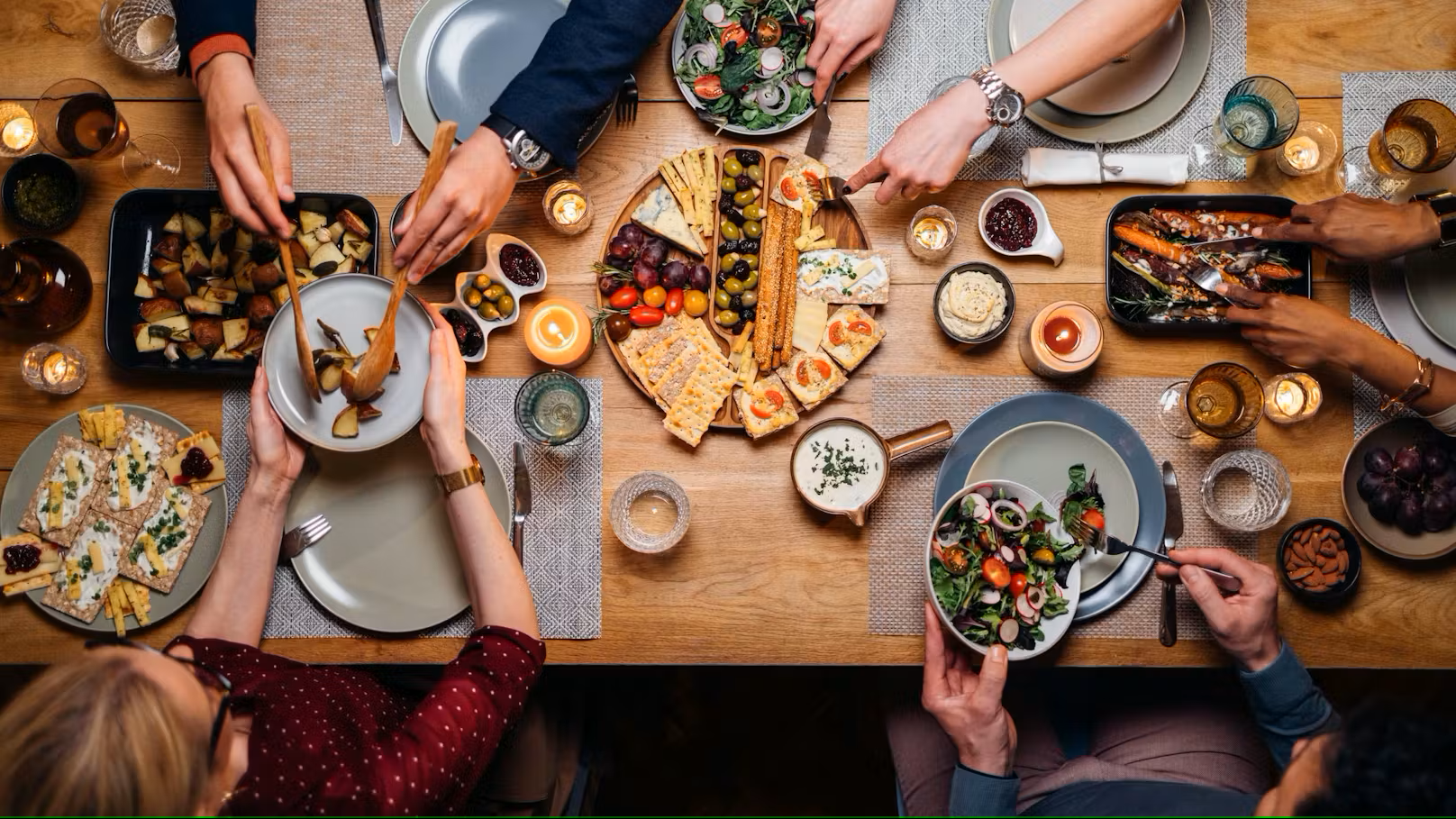 Obenansicht eines gedeckten Tisches mit Leuten, die sich Essen auftun