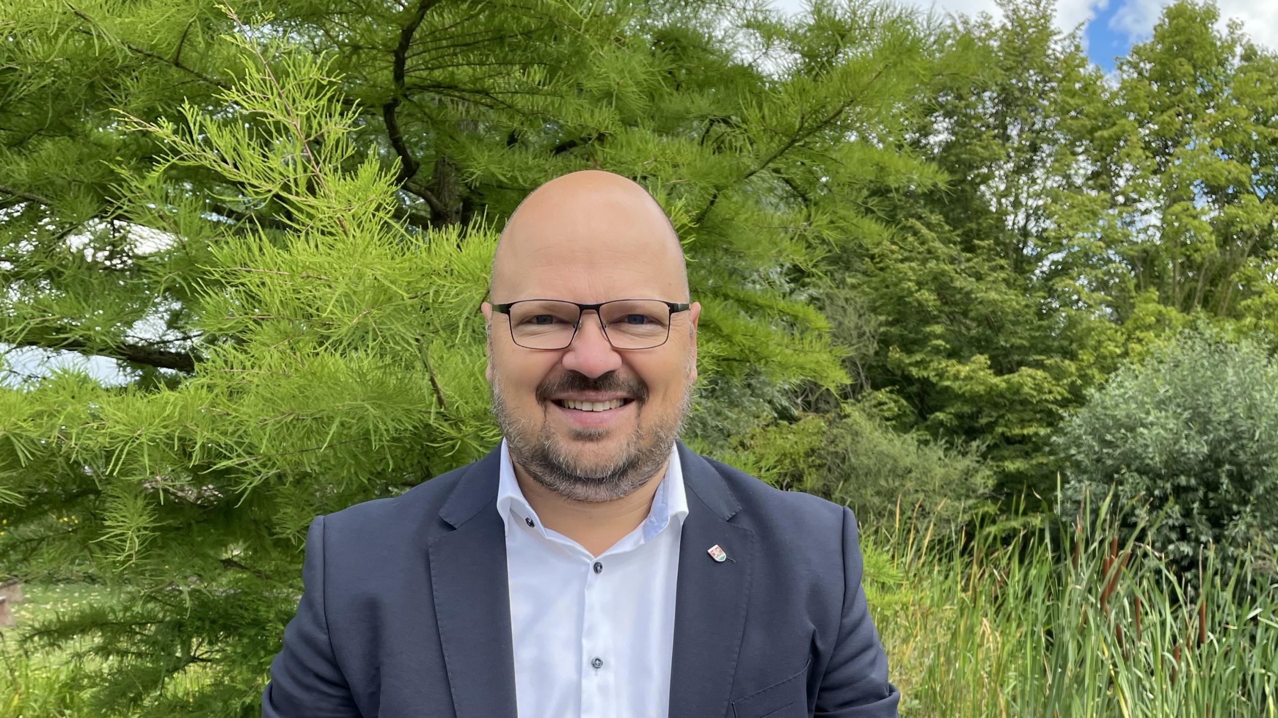 Portrait von Bürgermeister Kai Eggert im grünen Park der Sinne