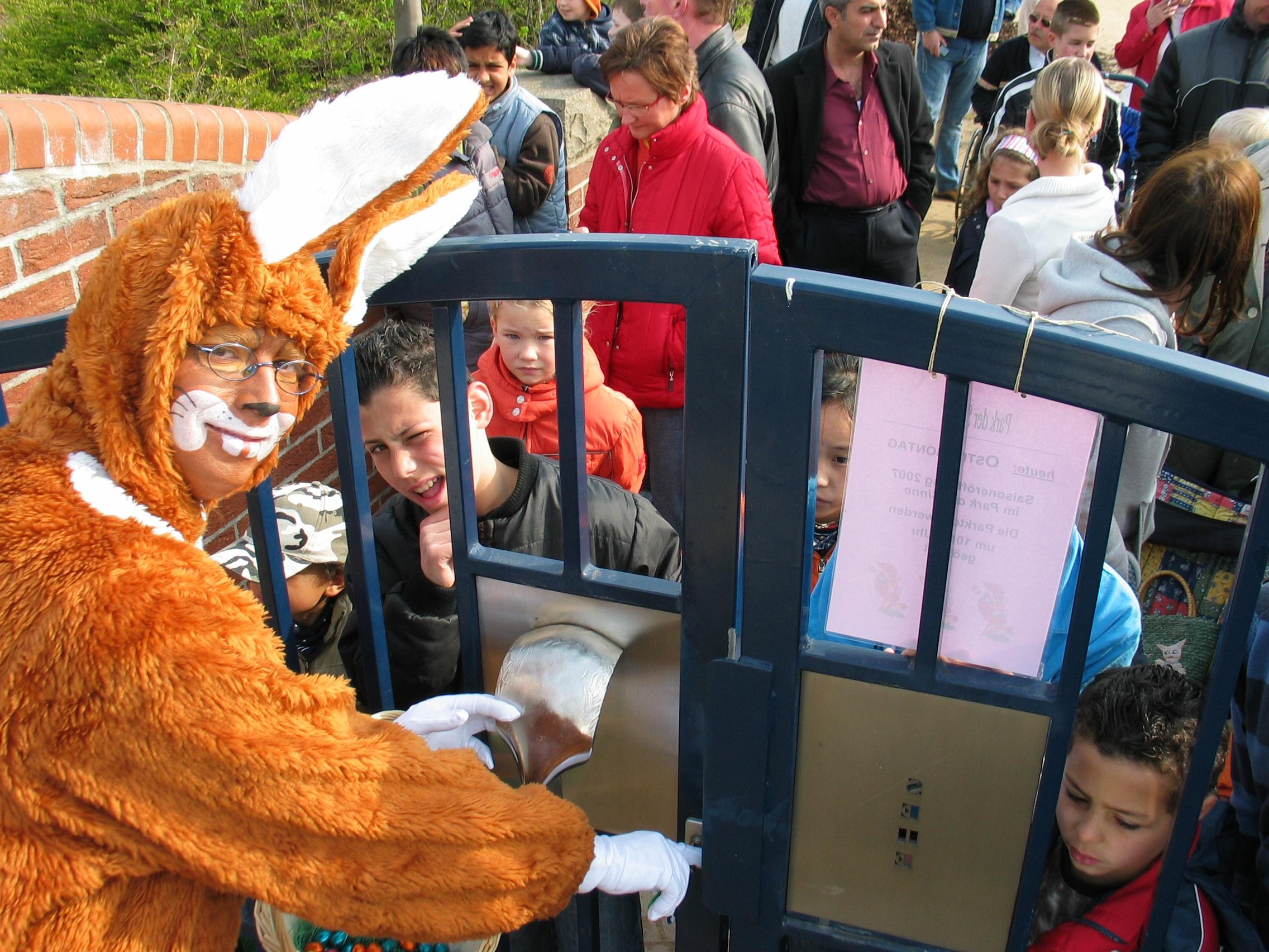 Mann im Hasenkostüm öffent das Tor zum Park der Sinne