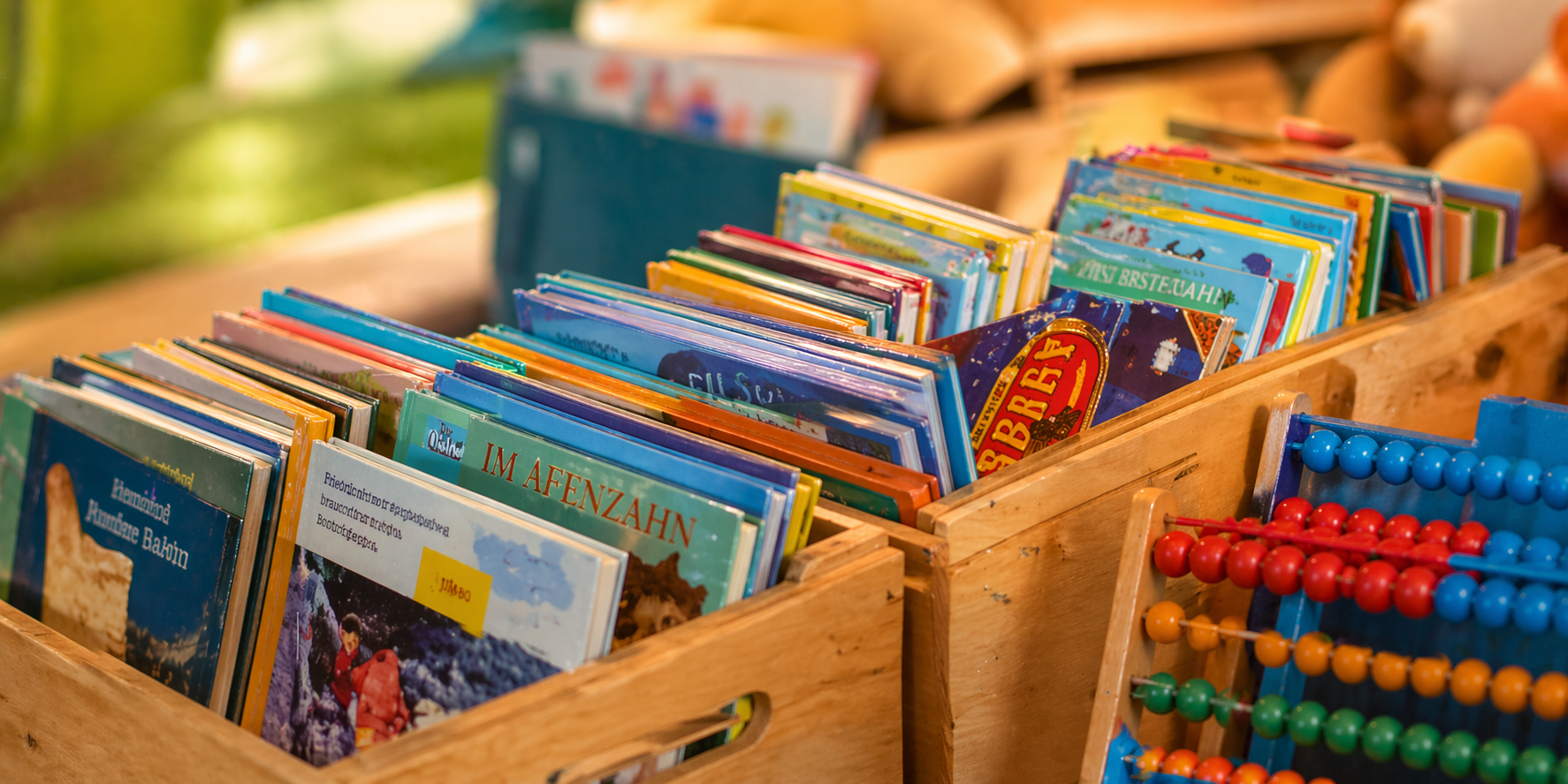 verschiedene Bücherkisten, ein Abakus lehnt davor