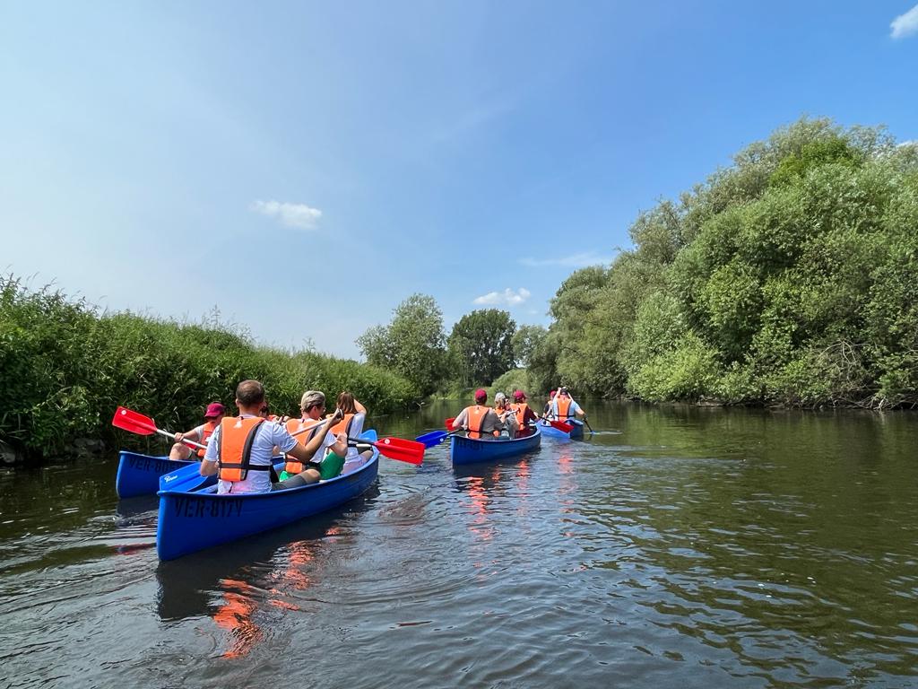 Kanuboote mit Personen besetzt, die auf einem Fluss fahren