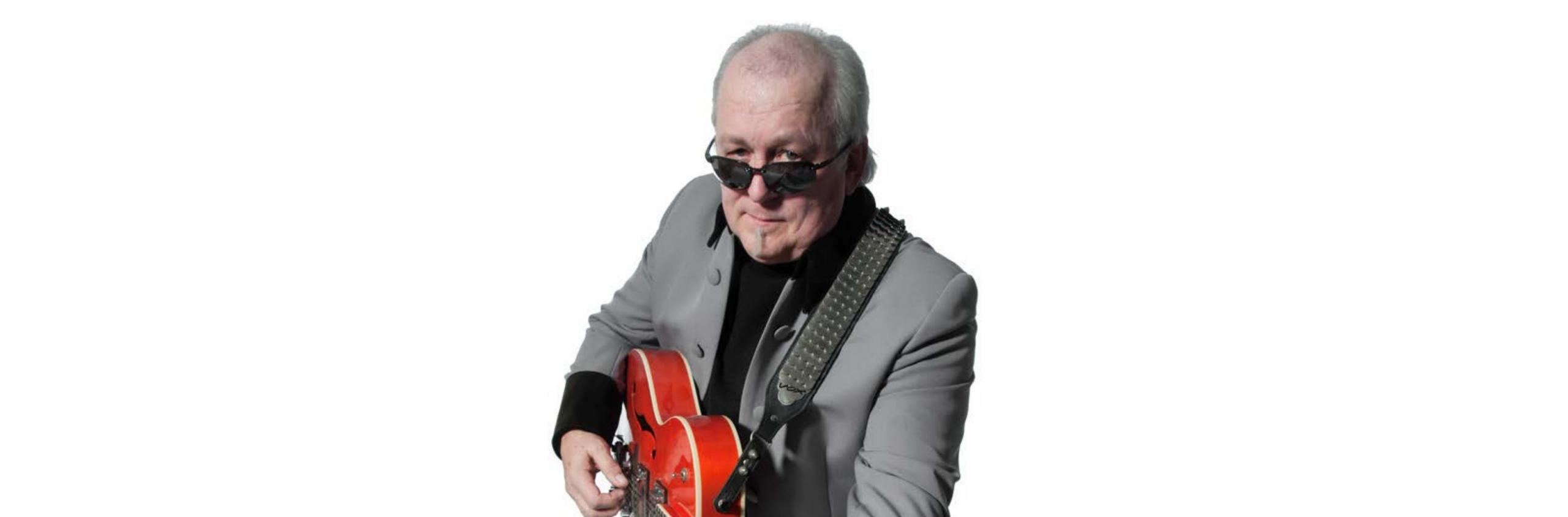 Ein Mann mit Sonnenbrille spielt auf einer Gitarre.