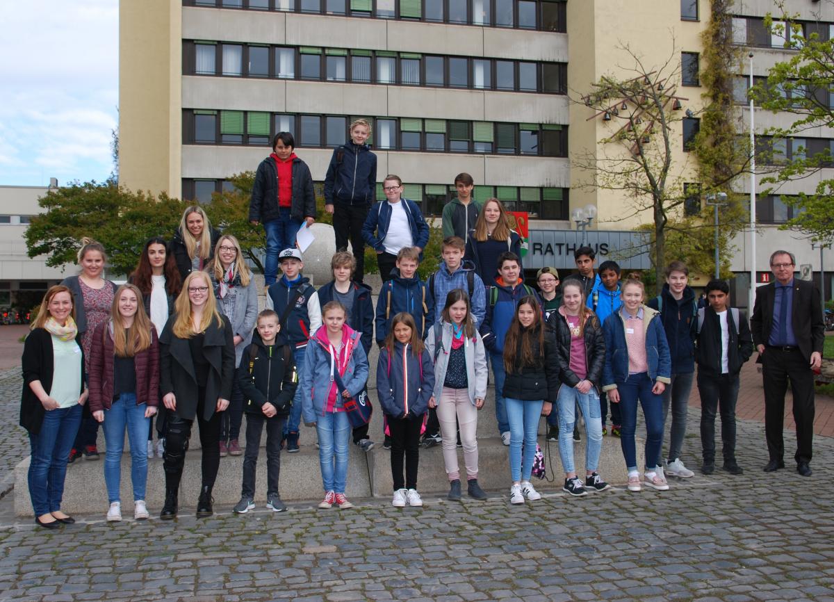 25 Schülerinnen und Schüler waren in der Stadtverwaltung zu Gast und wurden Bürgermeister Köhne begrüßt. Gruppenfoto vor dem Rathaus mit den Auszubildenden und einigen Mitarbeiterinnen.