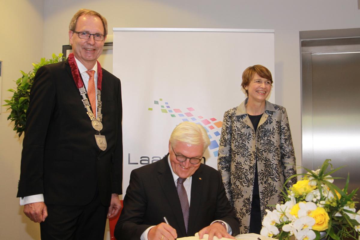 Steinmeier bei der Unterschrift, neben ihm seine Frau Elke Büdenbender und Bürgermeister Jürgen Köhne