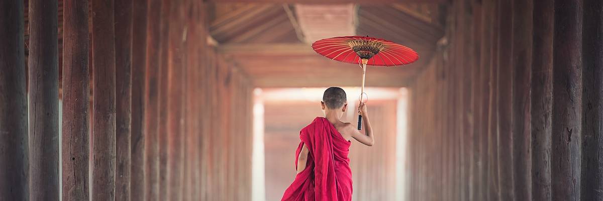 Junge im asiatischen Gewand mit traditionellem Schirm