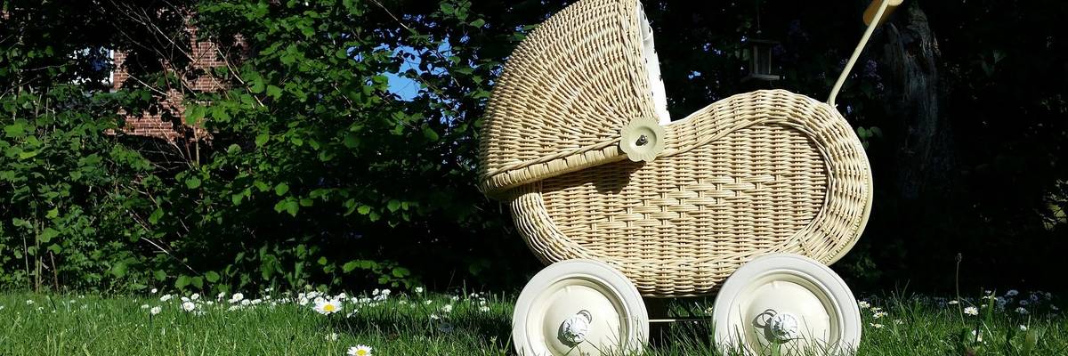 nostalgischer Puppenwagen auf einer grünen Wiese