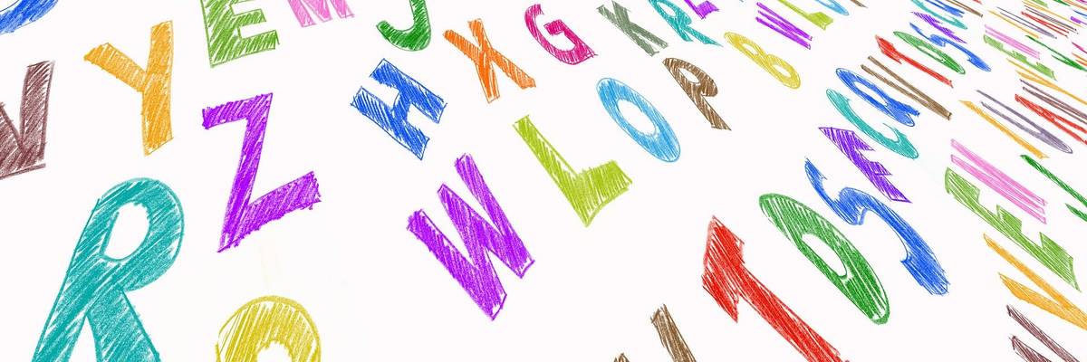 Bunte Buchstaben sind auf einer weißen Fläche in Reihen gelegt.