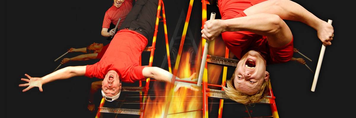 Männer hängen kopfüber an einer Leiter. Unten