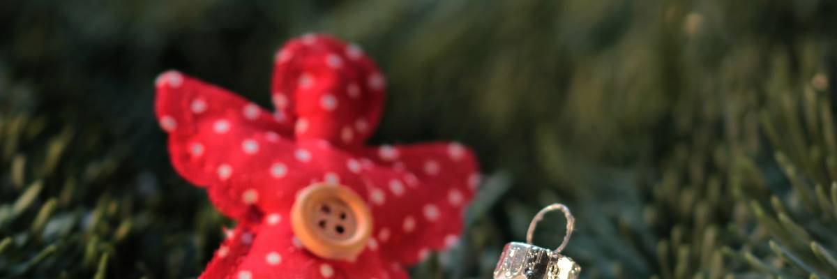 Kleiner Weihnachtsengel aus rotem Stoof mit Knop und eine kleine weiße Christbaumkugel mit &#39;Merry Xmas&#39;