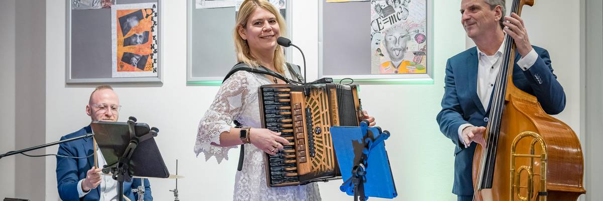 Eine Musikband steht auf einer Bühne und musiziert.