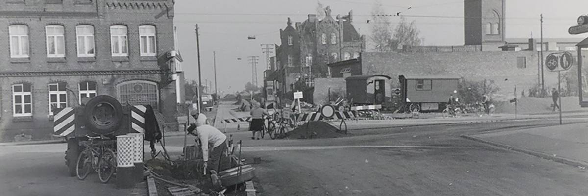 Auf dem Bild ist Alt Laatzen in den früheren Zeiten zu sehen. im Vordergrund sind zwei Männer mit Bauarbeiten beschäftigt und im Hintergrund ist die Straße abgesperrt.
