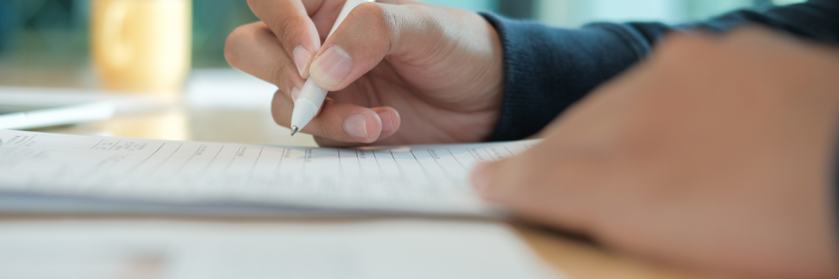 Eine Person füllt handschriftlich einen Zettel aus