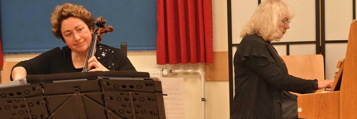 zwei Frauen, eine spielt Klavier, die andere Cello