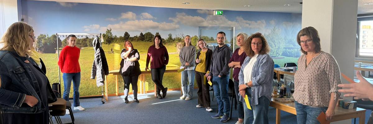 Die Fachkräfte stehen im Halbkreis und legen in die Mitte Metaplankarten. Sie erharbeiten sich ein Thema.