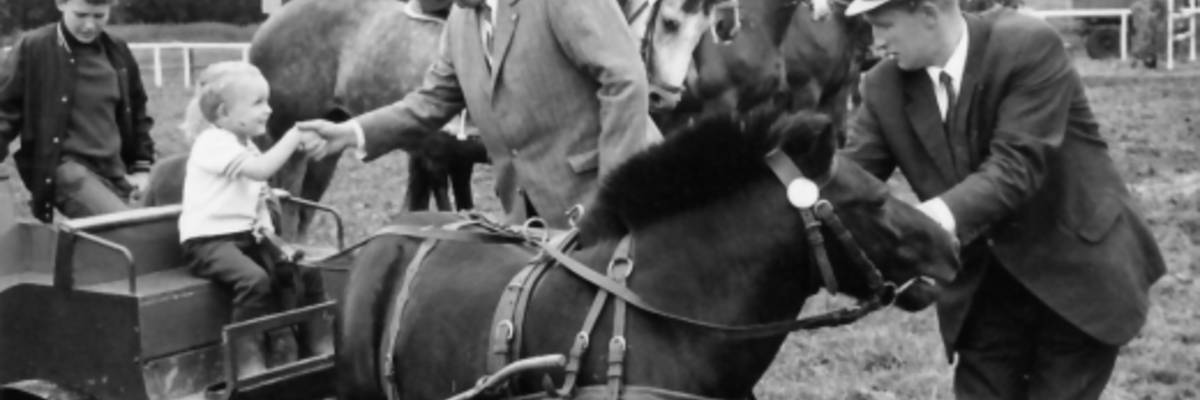 Erich Kraushaar gibt Kind auf Pferdekarren die Hand