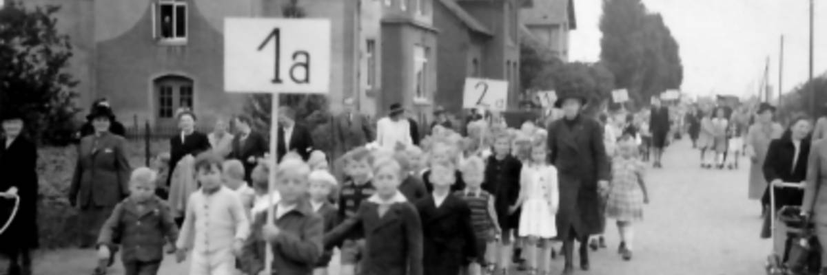 Schüler mit Schild der Klasse marschieren durch die Straßen