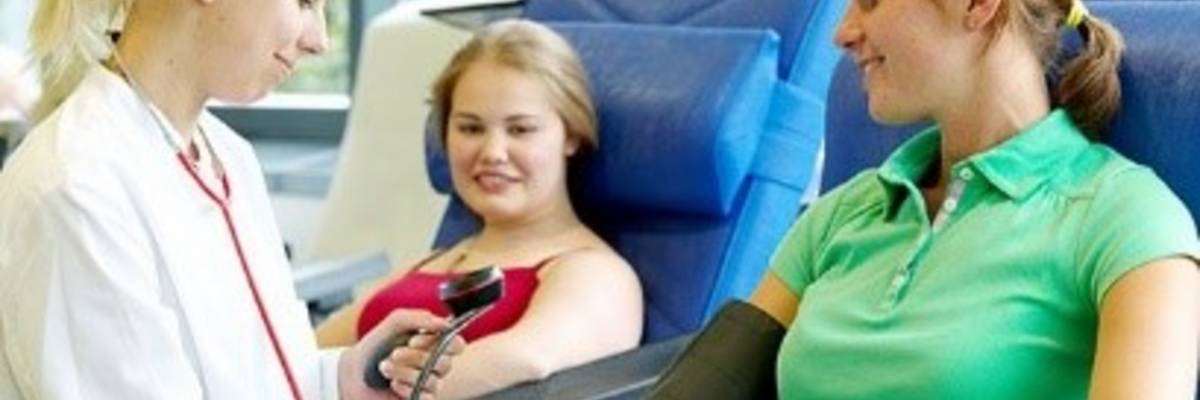 Ärztin misst vorbereitend Blutdruck bei einer Patientin