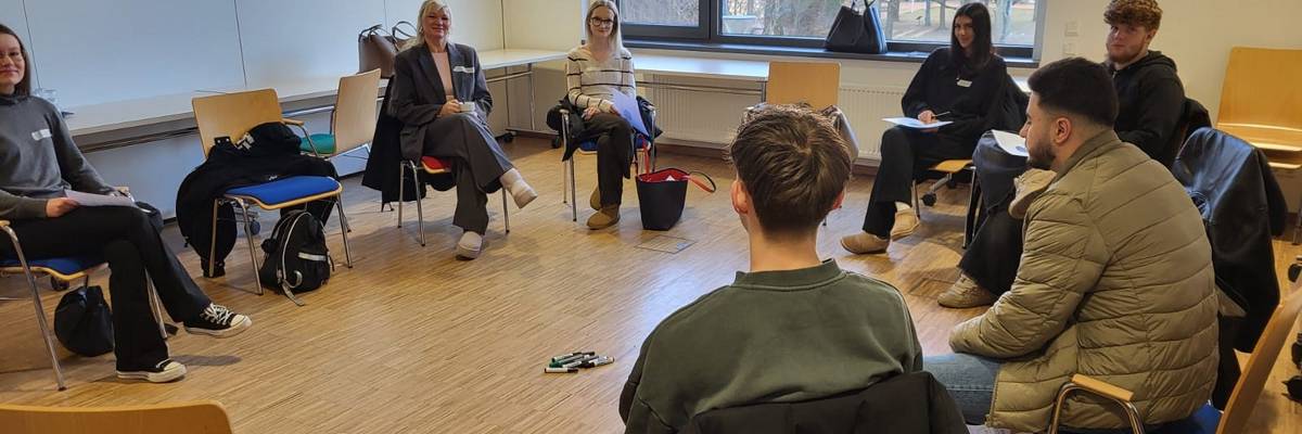 Die Teilnehmenden sitzen in einem Stuhlkreis.