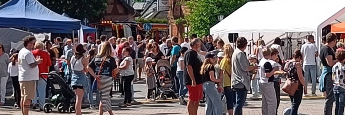 Blick auf das Dorffest mit Besuchenden und Ständen