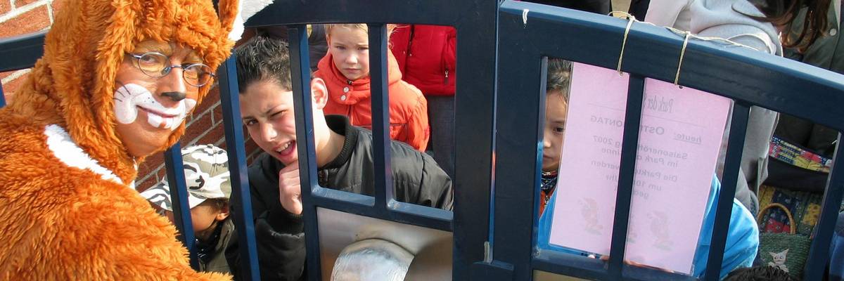 Mann im Hasenkostüm öffent das Tor zum Park der Sinne