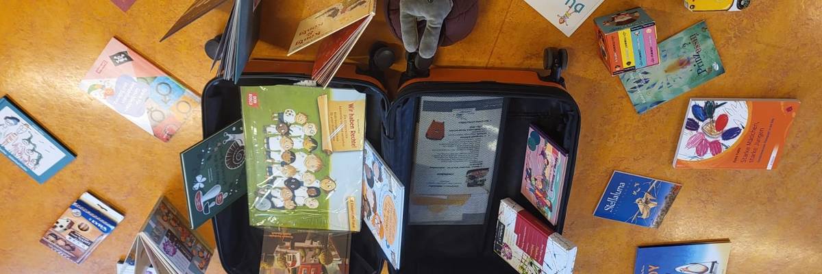 In der Mitte des Stuhlkreises sind Bücher ausgestellt. Einige Bücher liegen auf dem Boden. Einige Bücher wurden aufgestellt.