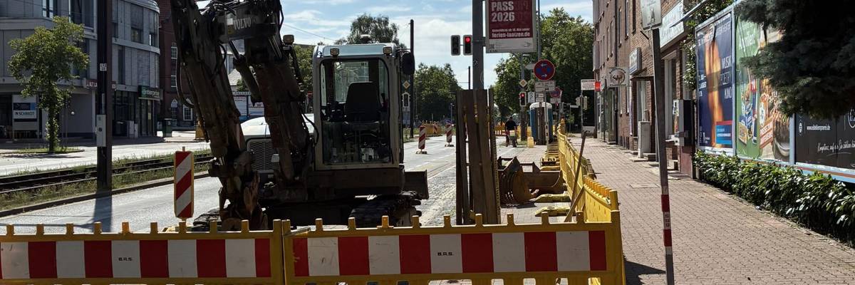 Umbau der Veloroute 8 - Blickrichtung entlang der Hildesheimer Straße nach Süden © Stadt Laatzen Gelbe Baustellenbaken sperren eine Baustelle ab, auf der bereits ein Bagger steht.