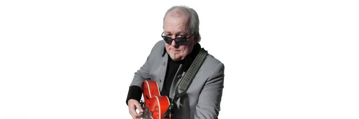 Ein Mann mit Sonnenbrille spielt auf einer Gitarre.