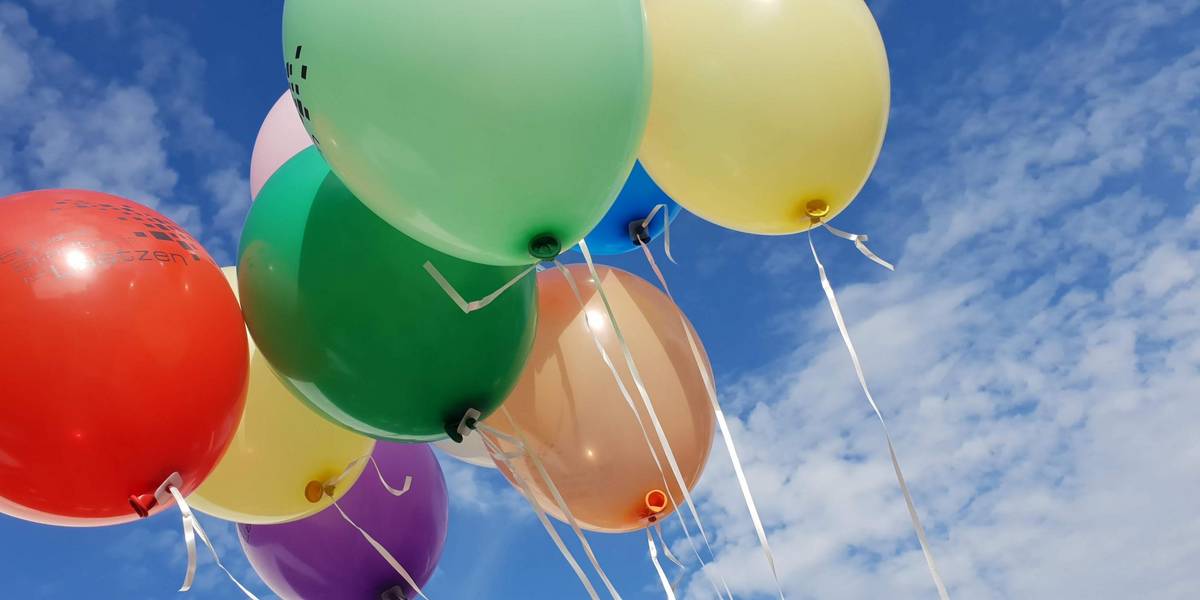 Luftballons mit Laatzen-Schriftzug vor blauem Himmel