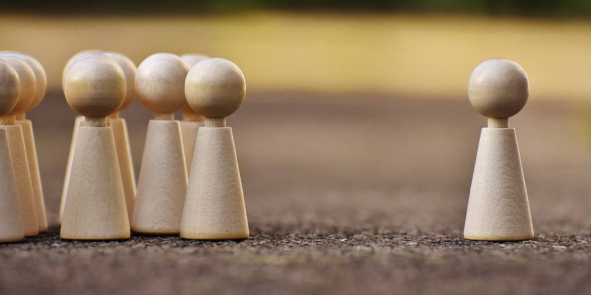 Spielfiguren Spielfiguren stehen sich gegenüber. Auf der einen Seite eine Grußße, auf der anderen Seite eine einzelne Spielfigur.