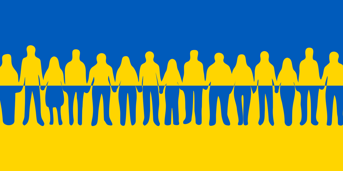 Gelb-Blaue Flagge mit einer Menschenkette davor