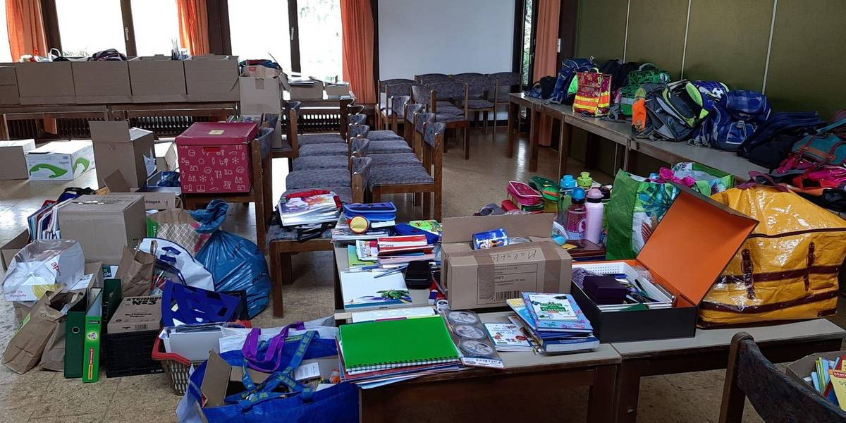Tische und Kartons sind voller Schulmaterialien.